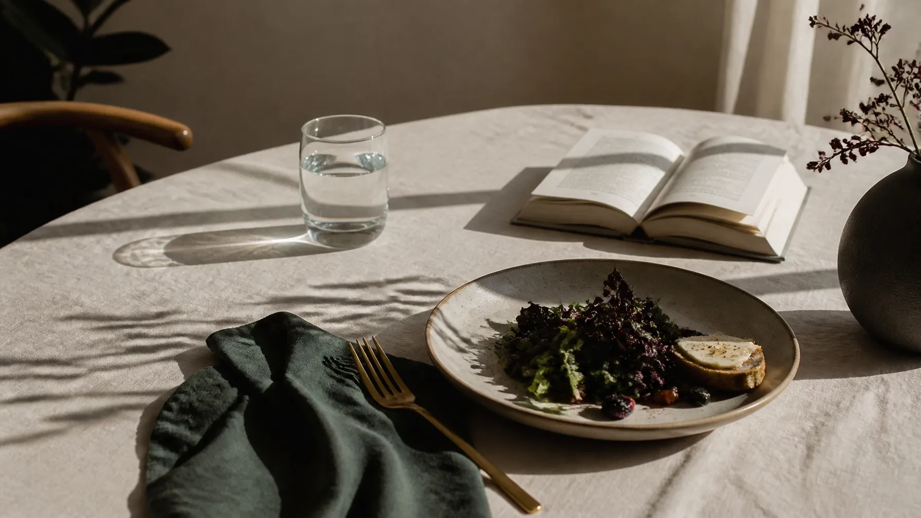 Mesa posta de forma simples com livro, água e luz do fim da tarde em composição editorial silenciosa