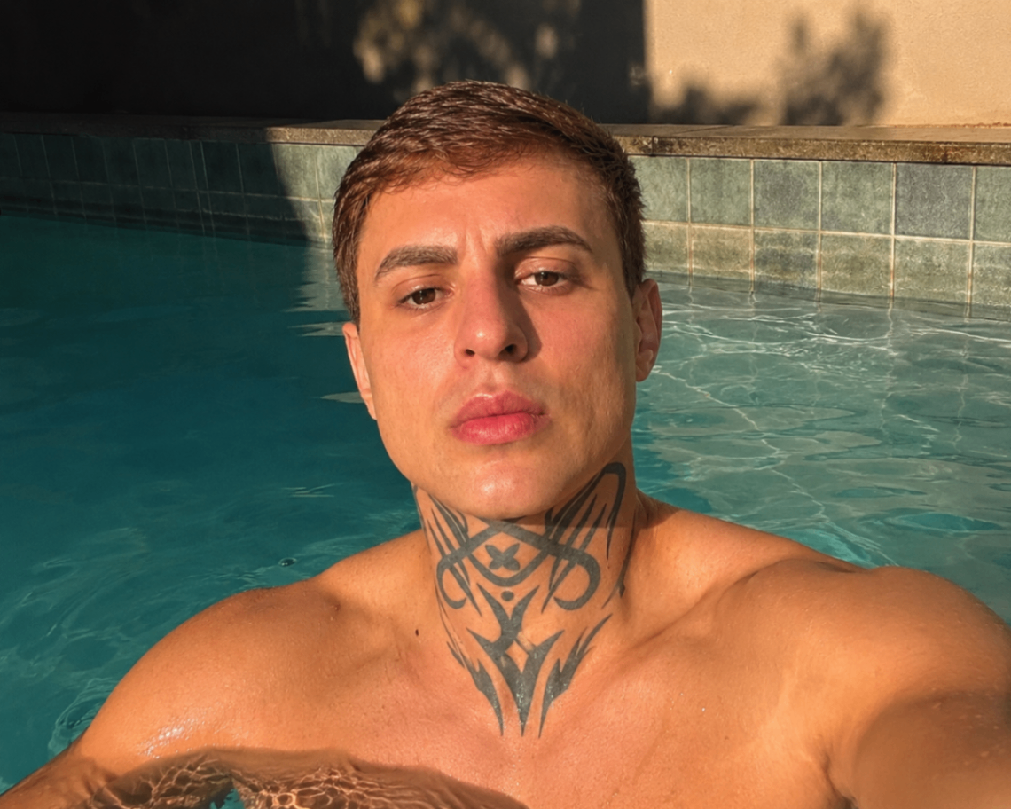 Victor Lemos em uma piscina, com sua tatuagem no pescoço visível
